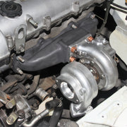 Blip speed 1.6l miata turbo manifold installed on a motor as part of a BEGI miata turbo kit